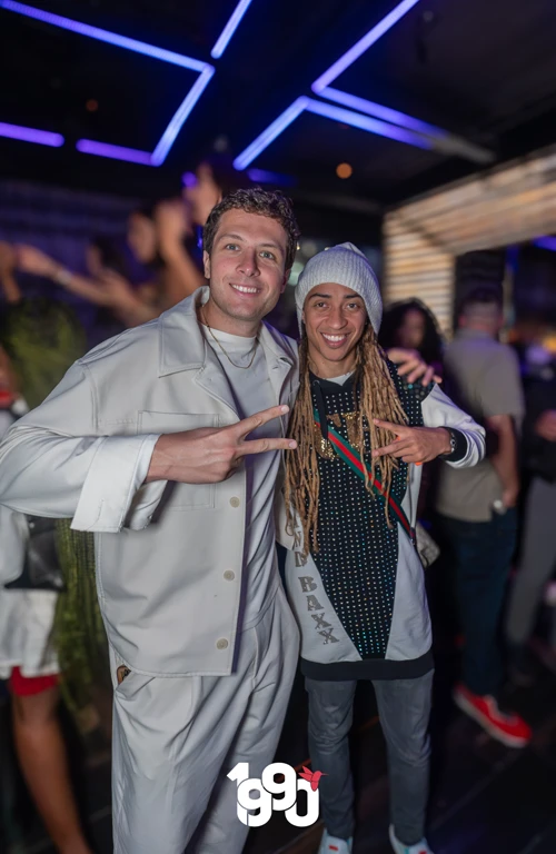 Two friends enjoying Fuego Thursdays Latin rooftop party in NYC nightlife.