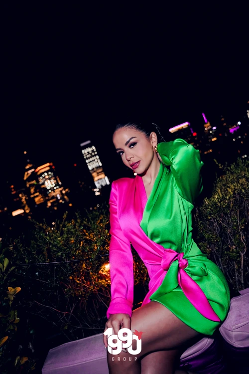 Stylish woman posing at Fuego Thursdays with the NYC skyline in the background during the rooftop party.