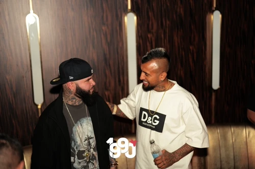 Two men conversing at Fuego Thursdays exclusive rooftop event.